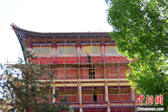 图为5月上旬，甘肃山丹县大佛寺内，工作人员对古建筑大雄宝殿进行修缮。 中新社记者 高展 摄
