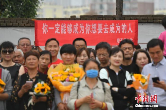 资料图:6月8日,云南省昆明市的考生结束2021年全国高考。图为考试结束后,一幅助考标语前有考生和家长合影留念。 <a target='_blank' data-cke-saved-href='http://www.chinanews.com/' href='http://www.chinanews.com/'><p align=