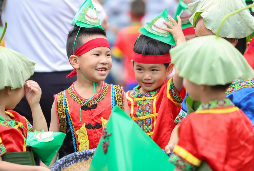 孩子们齐心协力搬运自己制作的粽子。胡攀学摄