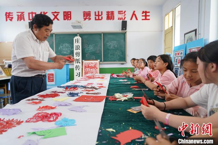 图为剪纸传承人李敏贤给中学生上剪纸教学课。(资料图) 李顺民 摄