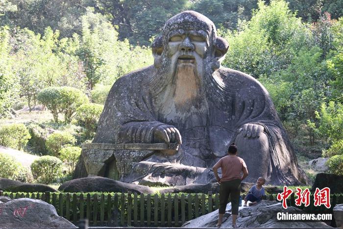 7月9日,一名小朋友在家长带领下,在泉州清源山的老君岩造像边玩耍。蒋启明 摄 点击进入下一页