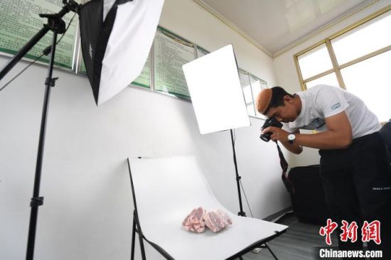 张忠山自学拍摄技术，给产品拍照。(资料图) 杨艳敏 摄