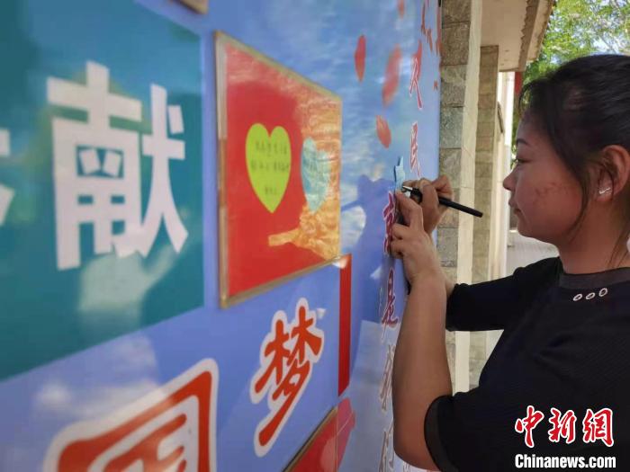 图为村民在“梦想墙”上写心愿。 史静静 摄 图为村民在“梦想墙”上写心愿。 史静静 摄