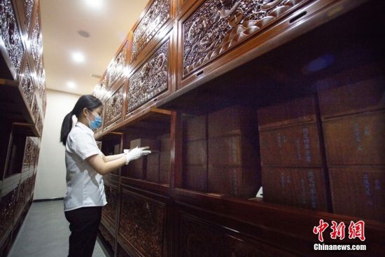 8月17日，甘肃省兰州市天庆博物馆的工作人员在整理该馆收藏的文渊阁版《四库全书》影印本。中新社记者 高展 摄