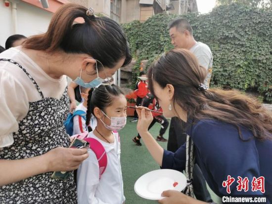 9月1日，兰州市七里河区火星街教育集团火星街小学举行丰富多彩的入学仪式。图为老师为新生点朱砂启蒙。　杨娜　摄