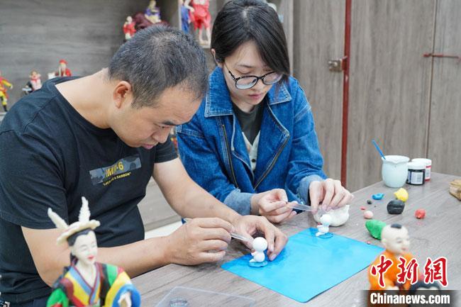 <a target='_blank'  data-cke-saved-href='http://www.chinanews.com/' href='http://www.chinanews.com/'>中新社</a>记者(右)现场体验面塑制作过程。　陈争强 摄