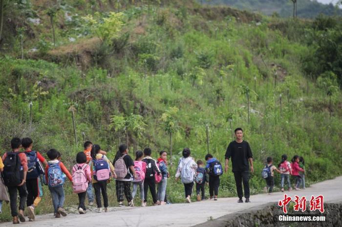 资料图:一名“90后”乡村教师组织学生排队上下学。 <a target='_blank' data-cke-saved-href='http://www.chinanews.com/' href='http://www.chinanews.com/'>中新社</a>记者 瞿宏伦 摄 点击进入下一页