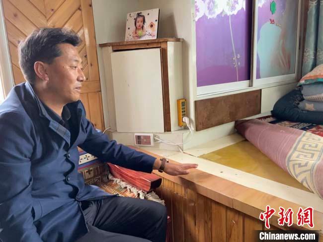 图为加拉尕玛村党工委书记阿黑介绍村民家的碳纤维电热炕板。 宋子昕 摄 图为合作市坚木克尔街道党工委书记阿黑介绍村民家的碳纤维电热炕板。 宋子昕 摄