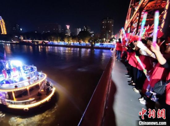 图为中山铁桥的游客手持五星红旗共唱红歌祝福祖国。　牛小忆 摄