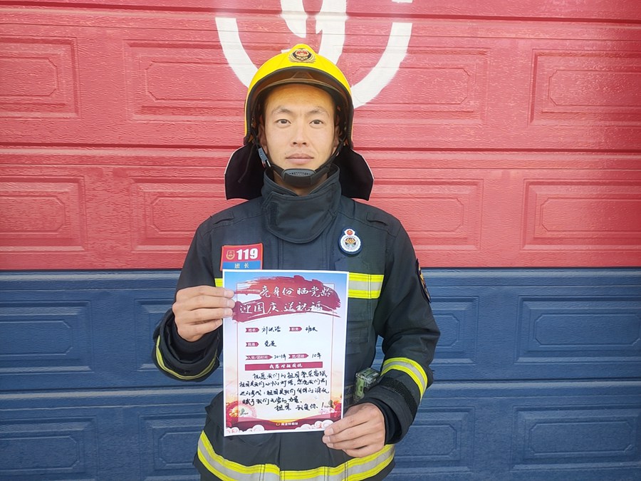 消防员展示手写的祝福卡片。谢苑瑾、钱万梓摄