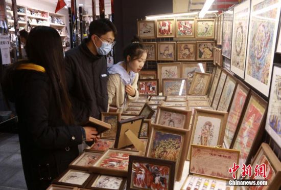 图为游客在敦煌夜市工艺品一条街选购旅游工艺品。 张晓亮 摄