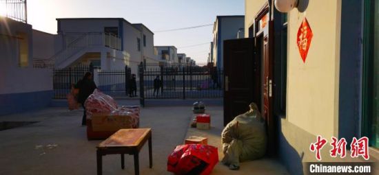 图为搬迁民众收拾东西住新家。 魏建军 摄 图为搬迁民众收拾东西住新家。 魏建军 摄