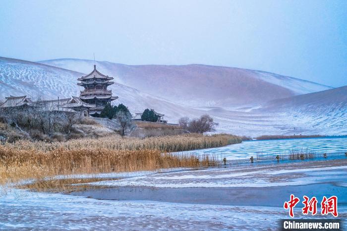 2021年11月28日,雪落鸣沙山月牙泉景区。 王斌银 摄 2021年11月28日,雪落鸣沙山月牙泉景区。 王斌银 摄