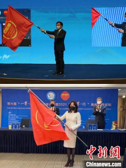 图为甘肃省外办主任张宝军向韩中文化友好协会会长曲欢传递“一带一路”国际青年论坛旗帜。　韩中文化友好协会供图