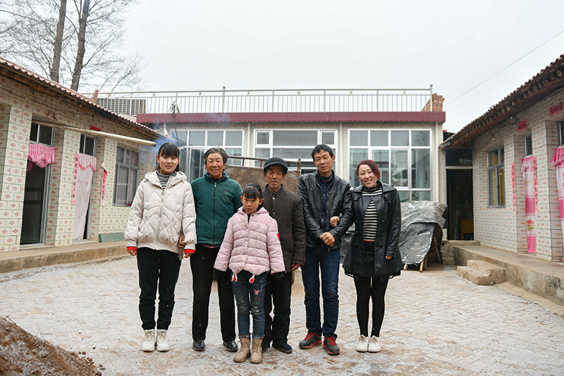 2020年1月9日,元古堆村村民在自家新房前拍摄全家福。