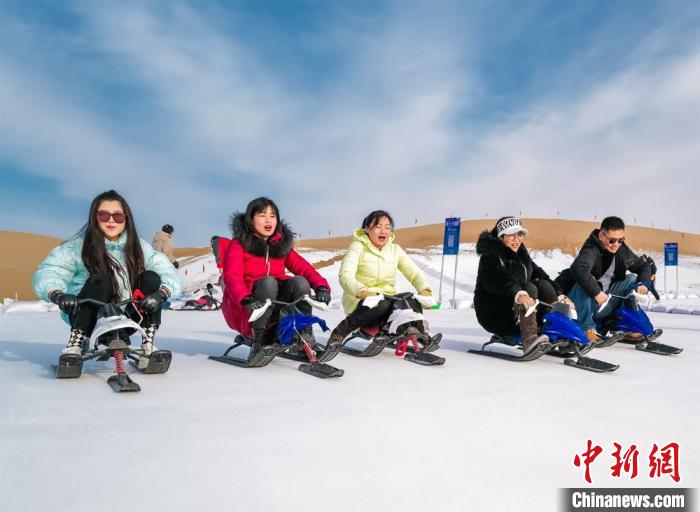 图为新年伊始，游客在敦煌沙漠露营基地享受滑雪的乐趣。　张晓亮 摄