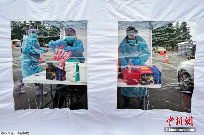 图三 当地时间1月4日,美国华盛顿州普亚卢普,核酸检测站点的工作人员在帐篷里做准备工作。 点击进入下一页