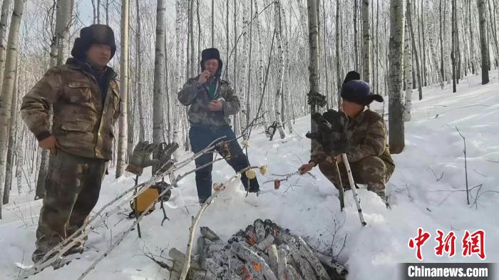 图为中午,林业工人们点起一堆火,将馒头、腌肉、鸡蛋串成串放在火上烤热,作为午餐。 何康红 摄 图为中午,林业工人们点起一堆火,将馒头、腌肉、鸡蛋串成串放在火上烤热,作为午餐。 何康红 摄