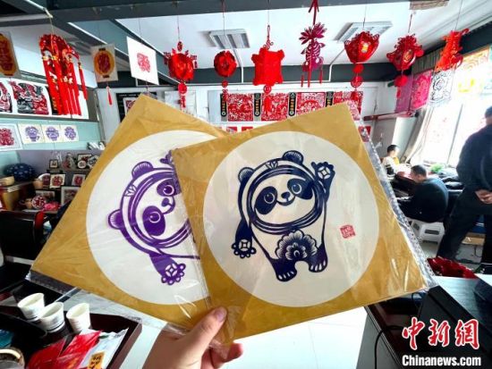 来自甘肃省庆阳市的剪纸传承人马路,凭借巧手剪出了冬奥会吉祥物“冰墩墩”。 徐雪 摄 来自甘肃省庆阳市的剪纸传承人马路,凭借巧手剪出了冬奥会吉祥物“冰墩墩”。 徐雪 摄