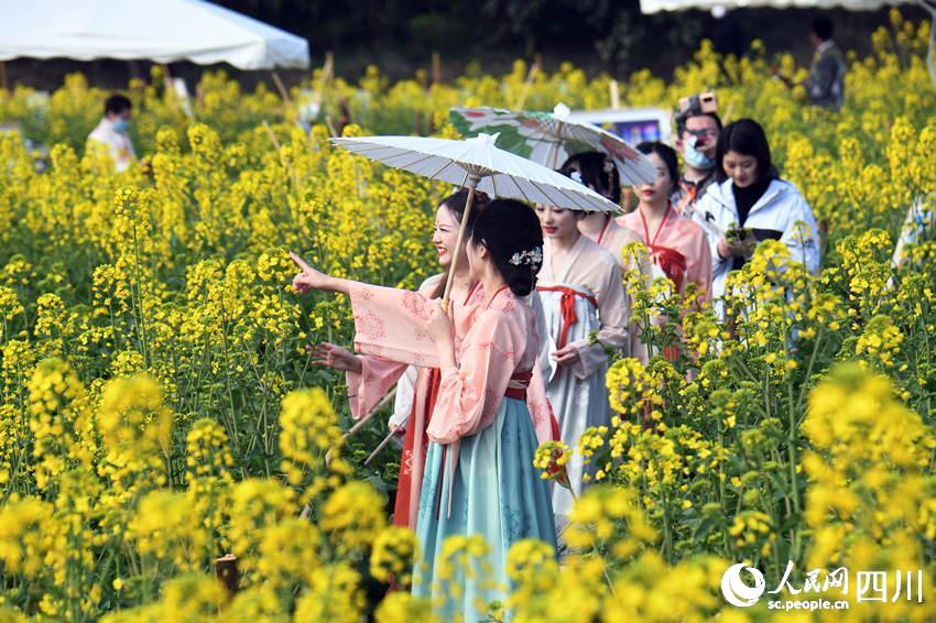 游客身穿汉服在油菜花田里嬉戏、拍照。蒋永平摄 