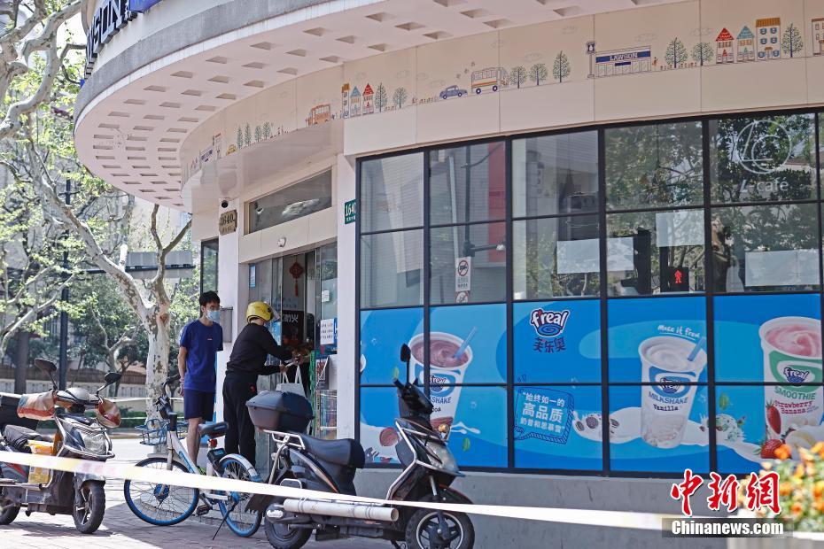 4月12日,上海淮海中路湖南路路口的罗森超市门口,派送人员等待拿取居民网上购买的物品。<a target='_blank' data-cke-saved-href='/' href='/'>中新社</a>记者 殷立勤 摄 点击进入下一页