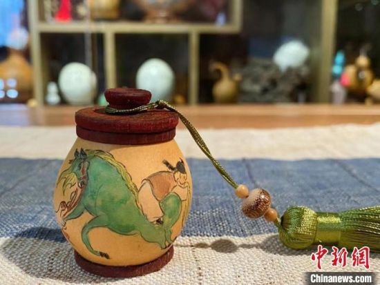 图为阮熙越将“绿马”等社会热点创新融入刻葫芦,制作出茶叶罐,增加其实用价值。(资料图) 阮熙越供图 图为阮熙越将“绿马”等社会热点创新融入刻葫芦,制作出茶叶罐,增加其实用价值。(资料图) 阮熙越供图