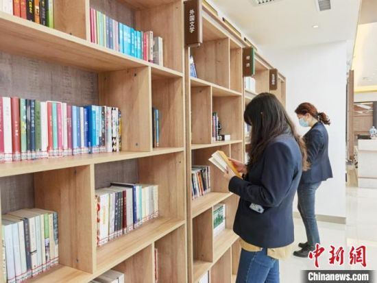 图为在甘肃公航旅建设集团有限公司的职工书屋,职工挑选书籍。 徐雪 摄 图为在甘肃公航旅建设集团有限公司的职工书屋,职工挑选书籍。 徐雪 摄