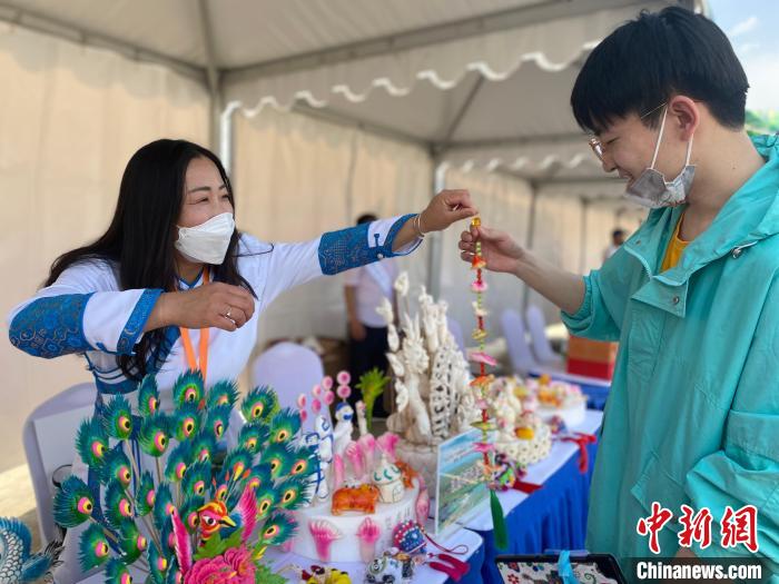 图为贺春梅将自己捏的寒燕送给民众。 张玮 摄 图为贺春梅将自己捏的寒燕送给民众。 张玮 摄