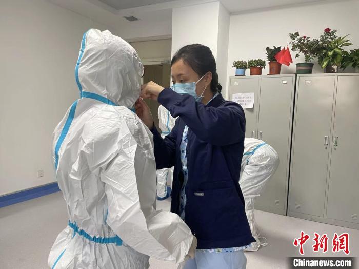 图为于冉为准备进入病区的医护人员检查个人防护。 受访者供图 图为于冉为准备进入病区的医护人员检查个人防护。 受访者供图