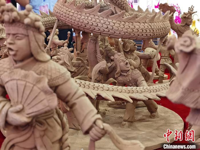 图为甘肃省临夏州非遗传承人常天平制作的农民舞狮舞龙舞狮闹社火泥塑群雕进行展出。　闫姣 摄