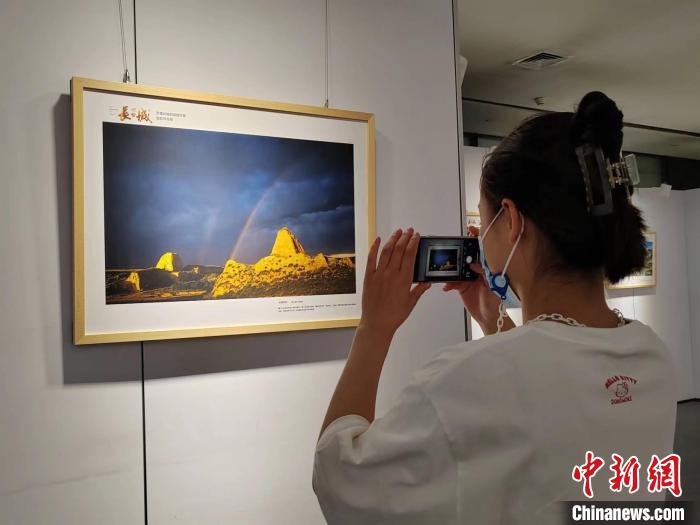 展览作品前，一名游客正在拍照留念。　高雨晴 摄