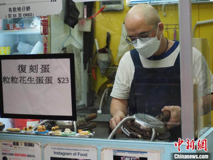 图为店主新哥正在制作本土美食鸡蛋仔。 中新社发 刘雨婷 摄 图为店主新哥正在制作本土美食鸡蛋仔。 中新社发 刘雨婷 摄
