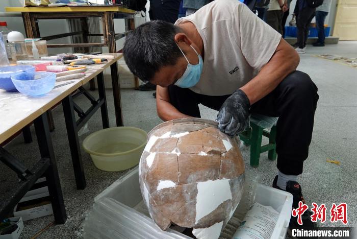 南佐遗址考古基地的整理室内，工作人员正在修复一件出土陶器。　<a target='_blank'  data-cke-saved-href='/' href='/'>中新社</a>记者 孙自法 摄