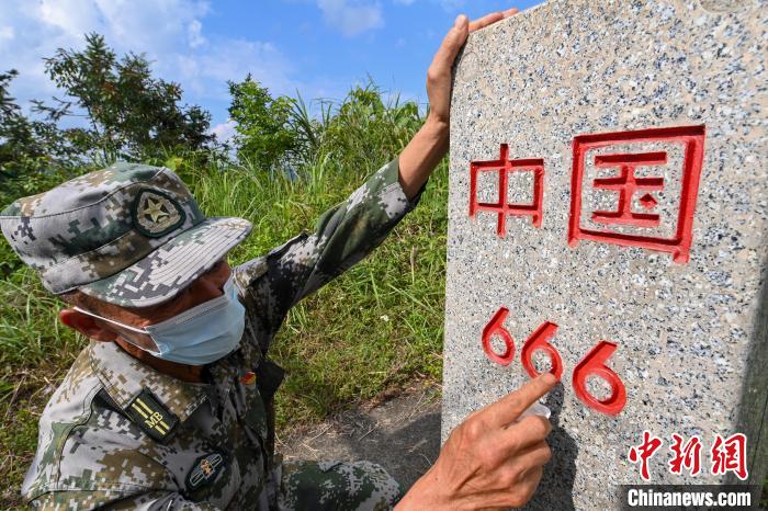 凌尚前擦拭界碑上的红字。　王以照 摄