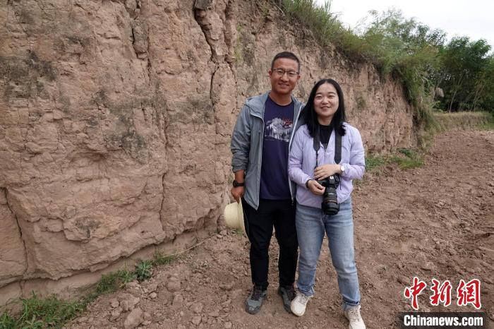 南佐遗址九座大型夯土台之一的土台遗存前，考古队骨干成员李小龙与考古同行的妻子袁晓合影。　中新社记者 孙自法 摄