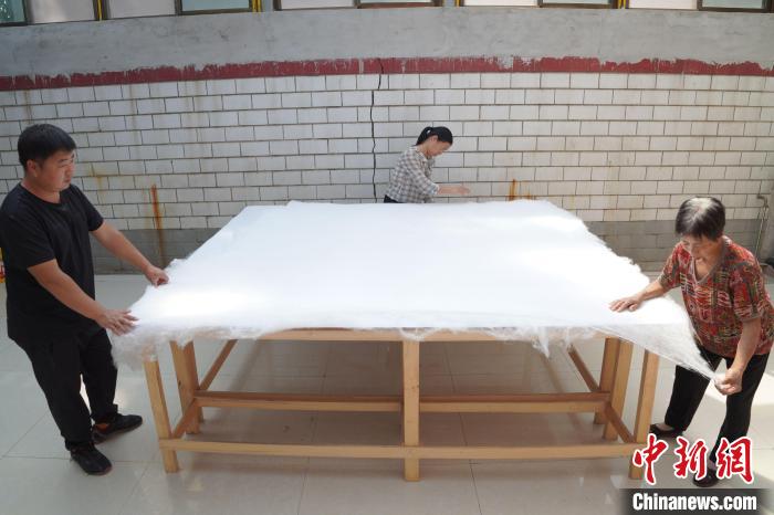 图为蚕农加工制作蚕丝被。 刘继东 摄 图为蚕农加工制作蚕丝被。 刘继东 摄