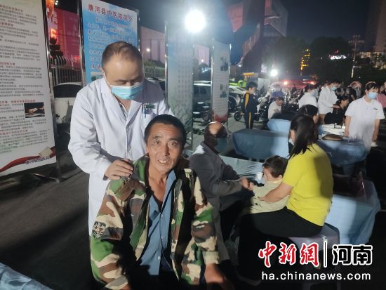 市民免费在唐河县“中医药文化夜市”上体验推拿按摩服务。王宇 摄 市民免费在唐河县“中医药文化夜市”上体验推拿按摩服务。王宇 摄