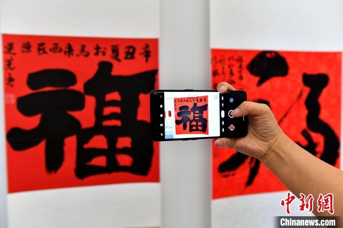 图为市民参观展览并拍照留念。 吕明 摄 图为市民参观展览并拍照留念。 吕明 摄