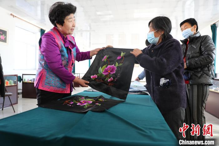 图为白晶莹验收绣工的作品。 科右中旗宣传部供图 图为白晶莹验收绣工的作品。 科右中旗宣传部供图