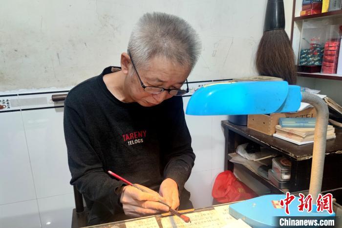 蓝田张氏毛笔制作技艺非遗传承人张才枝在为刚做好的毛笔刻字。 吴冠标 摄 蓝田张氏毛笔制作技艺非遗传承人张才枝在为刚做好的毛笔刻字。 吴冠标 摄