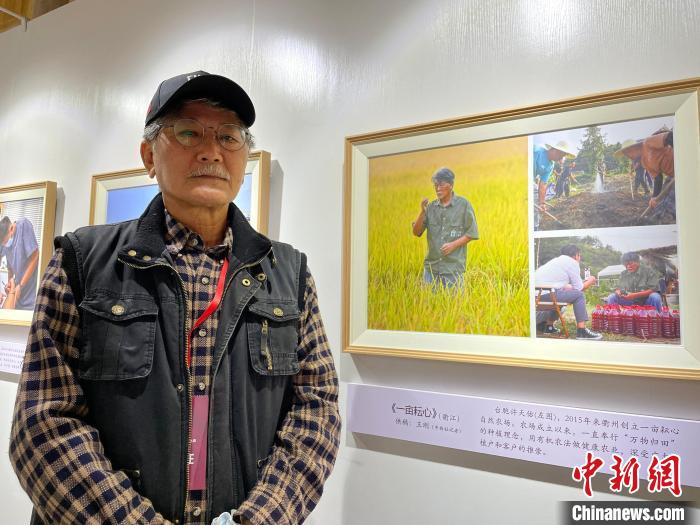 许天佑在<a target='_blank' data-cke-saved-href='/' href='/'>中新社</a>记者为其拍摄的展出照片前留影。 张斌 摄 许天佑在<a target='_blank' data-cke-saved-href='/' href='/'>中新社</a>记者为其拍摄的展出照片前留影。 张斌 摄