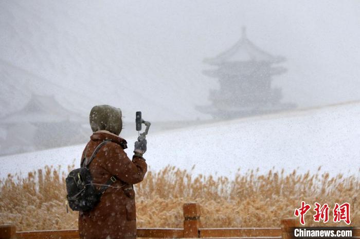 图为游人用手机记录难得一见的敦煌大漠雪景。　张晓亮 摄