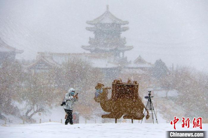 图为游人在敦煌大漠雪景中拍摄。　张晓亮 摄