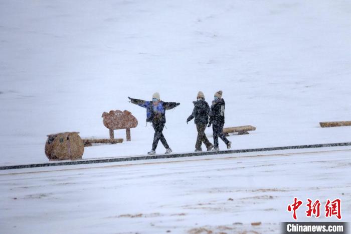 图为游人尽情体验敦煌大漠雪景。　张晓亮 摄