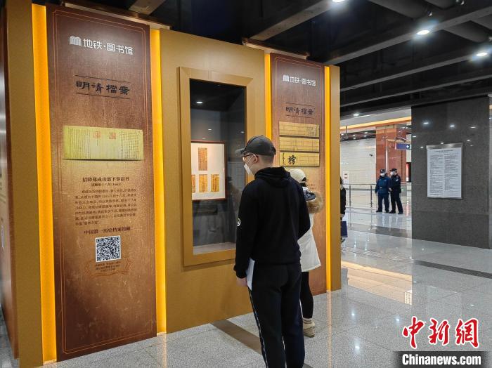 乘客在国家图书馆地铁站公益文化项目“探寻文明的印迹”中观赏展品 应妮 摄