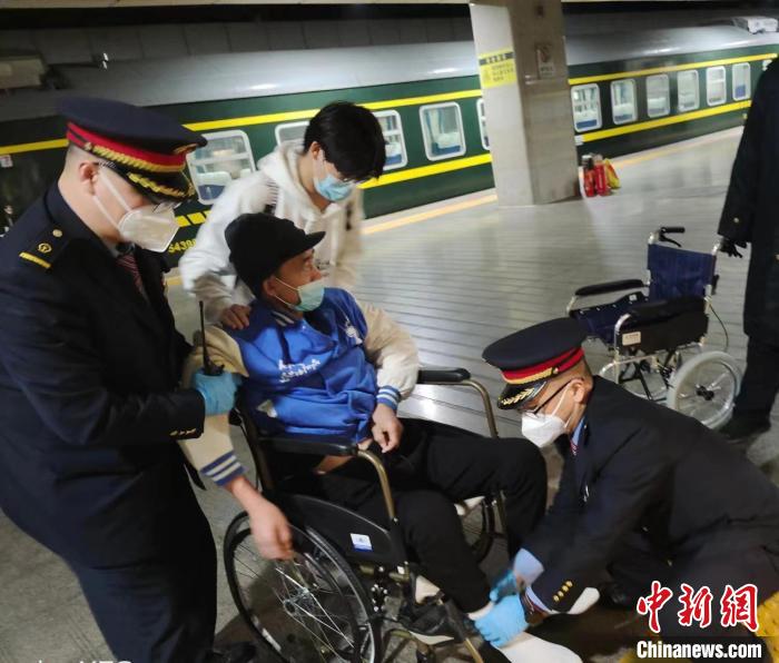 列车长孙高峰与同事为王先生提供帮助 赵林 摄 列车长孙高峰与同事为王先生提供帮助 赵林 摄