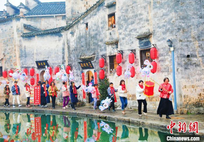 大年初一,游客和花灯队队员在黟县宏村月沼舞兔灯。 方龙 摄 大年初一,游客和花灯队队员在黟县宏村月沼舞兔灯。 方龙 摄