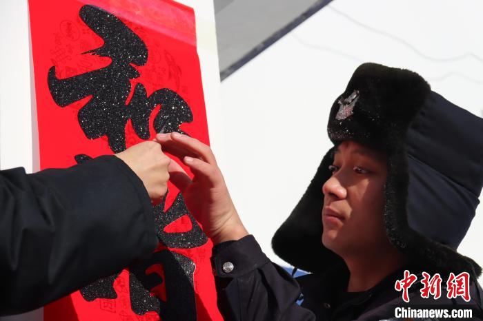 图为恩和哈达边境派出所民警贴春联。 牟东印 摄 图为恩和哈达边境派出所民警贴春联。 牟东印 摄