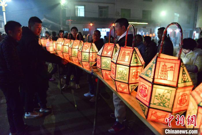 图为刻纸龙灯吸引了许多村民和游客前来观赏。 张斌 摄 图为刻纸龙灯吸引了许多村民和游客前来观赏。 张斌 摄