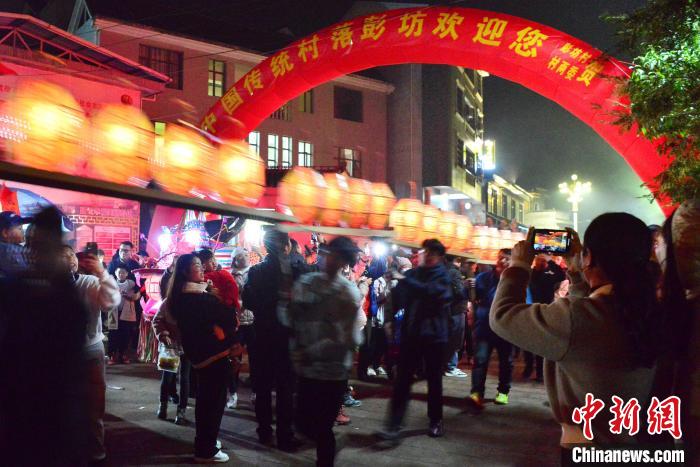 图为刻纸龙灯巡游吸引了许多民众前来观赏。 张斌 摄 图为刻纸龙灯巡游吸引了许多民众前来观赏。 张斌 摄